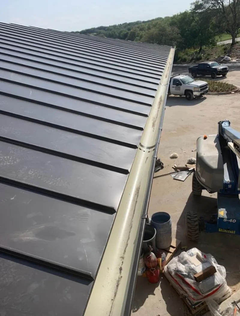 Standing seam panel and gutter detail on a metal roofing jobsite in Oak Grove
